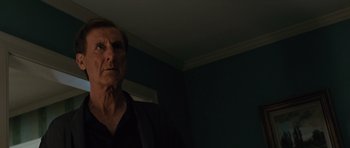 Movie still from “W.” (2008), directed by Oliver Stone – An older man standing in a dark room; Close Up shot, Low angle