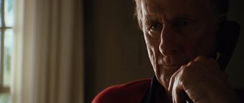 Movie still from “W.” (2008), directed by Oliver Stone – An older man is looking at the camera; Close Up shot, Over the shoulder angle