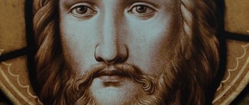 Movie still from “W.” (2008), directed by Oliver Stone – Image of the face of jesus; Extreme Close Up shot, Overhead angle