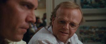 Movie still from “W.” (2008), directed by Oliver Stone – An older man wearing glasses talking to a younger man; Close Up shot, Over the shoulder angle