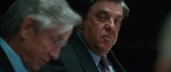Movie still from “W.” (2008), directed by Oliver Stone – A person wearing a suit and tie; Close Up shot, Over the shoulder angle
