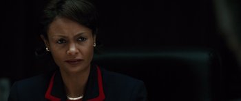 Movie still from “W.” (2008), directed by Oliver Stone – A woman in a black and red suit; Close Up shot, Over the shoulder angle