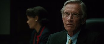 Movie still from “W.” (2008), directed by Oliver Stone – An older man and a younger woman in suits; Close Up shot, Over the shoulder angle