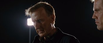 Movie still from “W.” (2008), directed by Oliver Stone – A person wearing a black shirt; Close Up shot, Low angle