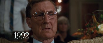 Movie still from “W.” (2008), directed by Oliver Stone – An older man wearing glasses and wearing a suit; Close Up shot, Low angle