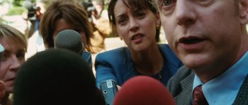 Movie still from “W.” (2008), directed by Oliver Stone – A person surrounded by a group of people; Close Up shot, Over the shoulder angle