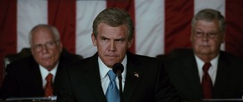 Movie still from “W.” (2008), directed by Oliver Stone – A person wearing a suit and tie; Close Up shot, Low angle