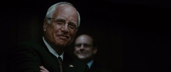 Movie still from “W.” (2008), directed by Oliver Stone – A man in a suit and tie next to another man in a suit and tie; Close Up shot, Over the shoulder angle