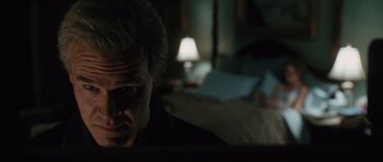 Movie still from “W.” (2008), directed by Oliver Stone – A man sitting in front of a laptop computer in a dark room; Close Up shot, Over the shoulder angle