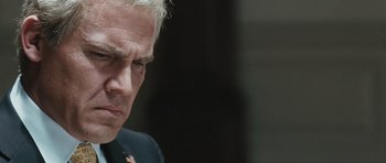 Movie still from “W.” (2008), directed by Oliver Stone – An older man with white hair is looking down; Close Up shot, Low angle