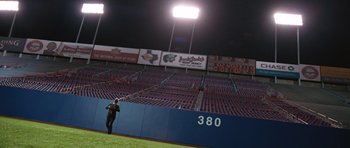 Movie still from “W.” (2008), directed by Oliver Stone – A baseball player standing in the outfield of a baseball field; Extreme Wide shot, Over the shoulder angle