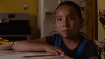 Movie still from “Waiting for Superman” (2010), directed by Davis Guggenheim – A young girl sitting at a table with a pencil; Close Up shot, Over the shoulder angle