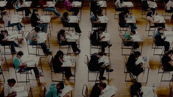 Movie still from “Waiting for Superman” (2010), directed by Davis Guggenheim – A group of people sitting at a table reading; Wide shot, Overhead angle