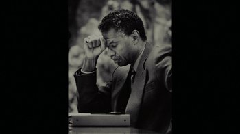 Movie still from “Waiting for Superman” (2010), directed by Davis Guggenheim – A black and white photo of a man sitting at a desk; Close Up shot, High angle