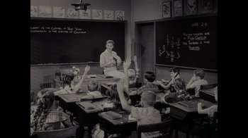 Movie still from “Waiting for Superman” (2010), directed by Davis Guggenheim – An old photo of a teacher and students in a class room; Wide shot, High angle
