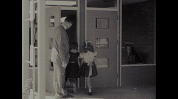 Movie still from “Waiting for Superman” (2010), directed by Davis Guggenheim – An old photo of a man and two little girls; Wide shot, Over the shoulder angle