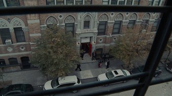 Movie still from “Waiting for Superman” (2010), directed by Davis Guggenheim – A view from a window of a building with people walking on the sidewalk; Extreme Wide shot, High angle