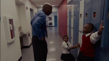 Movie still from “Waiting for Superman” (2010), directed by Davis Guggenheim – A man and two young children in a hallway; Medium shot, High angle