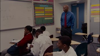 Movie still from “Waiting for Superman” (2010), directed by Davis Guggenheim – A man standing in front of a group of students; Medium shot, Over the shoulder angle
