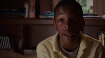 Movie still from “Waiting for Superman” (2010), directed by Davis Guggenheim – A young man sitting in front of a bookshelf; Close Up shot, High angle