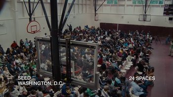 Movie still from “Waiting for Superman” (2010), directed by Davis Guggenheim – A large group of people sitting in a room; Extreme Wide shot, High angle