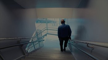 Movie still from “Waiting for Superman” (2010), directed by Davis Guggenheim – A man walking up a flight of stairs; Wide shot, Low angle