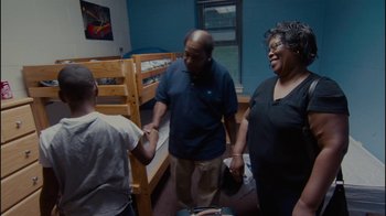 Movie still from “Waiting for Superman” (2010), directed by Davis Guggenheim – A man and a woman shake hands with a man in a blue shirt; Medium shot, High angle