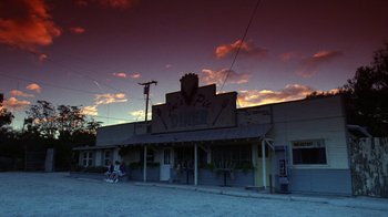 People sitting outside of a restaurant at dusk