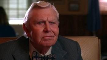 An older man wearing a suit and tie