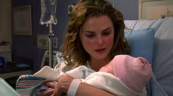 A woman holding a baby in her arms in a hospital bed