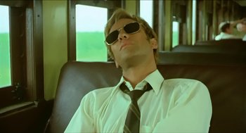 Movie still from “Wake in Fright” (1971), directed by Ted Kotcheff – A man in a white shirt and a black tie; Medium shot, Low angle