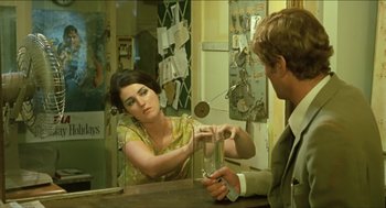 Movie still from “Wake in Fright” (1971), directed by Ted Kotcheff – A man and a woman sitting at a table; Medium shot, Over the shoulder angle