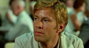 Movie still from “Wake in Fright” (1971), directed by Ted Kotcheff – A person with blond hair; Close Up shot, Low angle