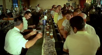 Movie still from “Wake in Fright” (1971), directed by Ted Kotcheff – A group of men sitting at a bar drinking beer; Wide shot, High angle