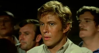 Movie still from “Wake in Fright” (1971), directed by Ted Kotcheff – A person wearing a white shirt; Close Up shot, Low angle