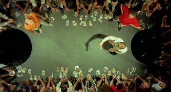 Movie still from “Wake in Fright” (1971), directed by Ted Kotcheff – An overhead view of a group of people sitting and standing around; Wide shot, Overhead angle