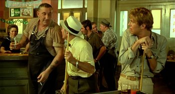 Movie still from “Wake in Fright” (1971), directed by Ted Kotcheff – A group of men standing in a room; Medium shot, Low angle