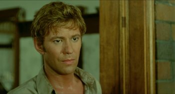 Movie still from “Wake in Fright” (1971), directed by Ted Kotcheff – A person wearing a brown shirt; Close Up shot, Over the shoulder angle