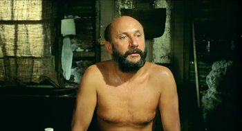 Movie still from “Wake in Fright” (1971), directed by Ted Kotcheff – A bald man with a beard and a mustache; Medium shot, Low angle