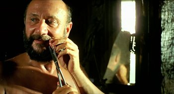 Movie still from “Wake in Fright” (1971), directed by Ted Kotcheff – A man is holding a pair of shears in front of a mirror; Close Up shot, Low angle