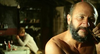 Movie still from “Wake in Fright” (1971), directed by Ted Kotcheff – A man with a beard is sitting next to a woman; Close Up shot, Over the shoulder angle