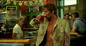 Movie still from “Wake in Fright” (1971), directed by Ted Kotcheff – A man drinking a beer in a restaurant; Medium shot, Over the shoulder angle