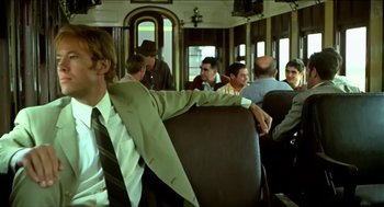 Movie still from “Wake in Fright” (1971), directed by Ted Kotcheff – A group of people sitting on a train; Medium shot, Over the shoulder angle