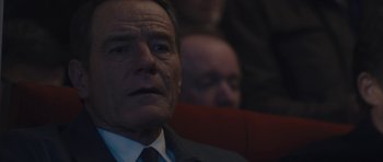 Movie still from “Wakefield” (2016), directed by Robin Swicord – A man in a suit and tie sitting in front of another man in a suit and tie; Close Up shot, Over the shoulder angle