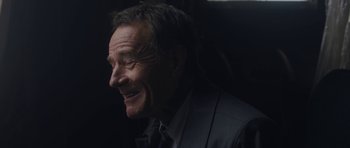 Movie still from “Wakefield” (2016), directed by Robin Swicord – An older man in a suit smiling for the camera; Close Up shot, Over the shoulder angle