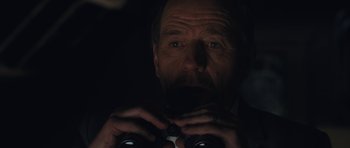 Movie still from “Wakefield” (2016), directed by Robin Swicord – A person looking through binoculars; Close Up shot, Low angle