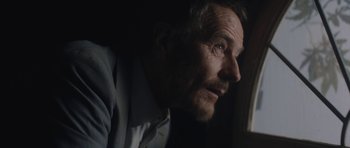 Movie still from “Wakefield” (2016), directed by Robin Swicord – An older man looking out of a window at night; Close Up shot, Low angle