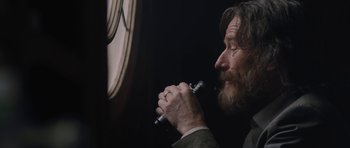 Movie still from “Wakefield” (2016), directed by Robin Swicord – A man with a beard is holding a pen in his mouth; Close Up shot, Over the shoulder angle