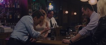 Movie still from “Wakefield” (2016), directed by Robin Swicord – A group of people sitting at a bar drinking beer; Medium shot, Over the shoulder angle