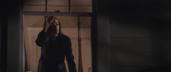 Movie still from “Wakefield” (2016), directed by Robin Swicord – A woman standing in front of an open window; Medium shot, Low angle